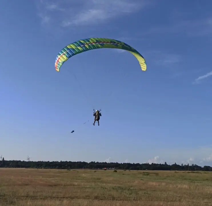 Paramotorpilot über einem weiten Feld