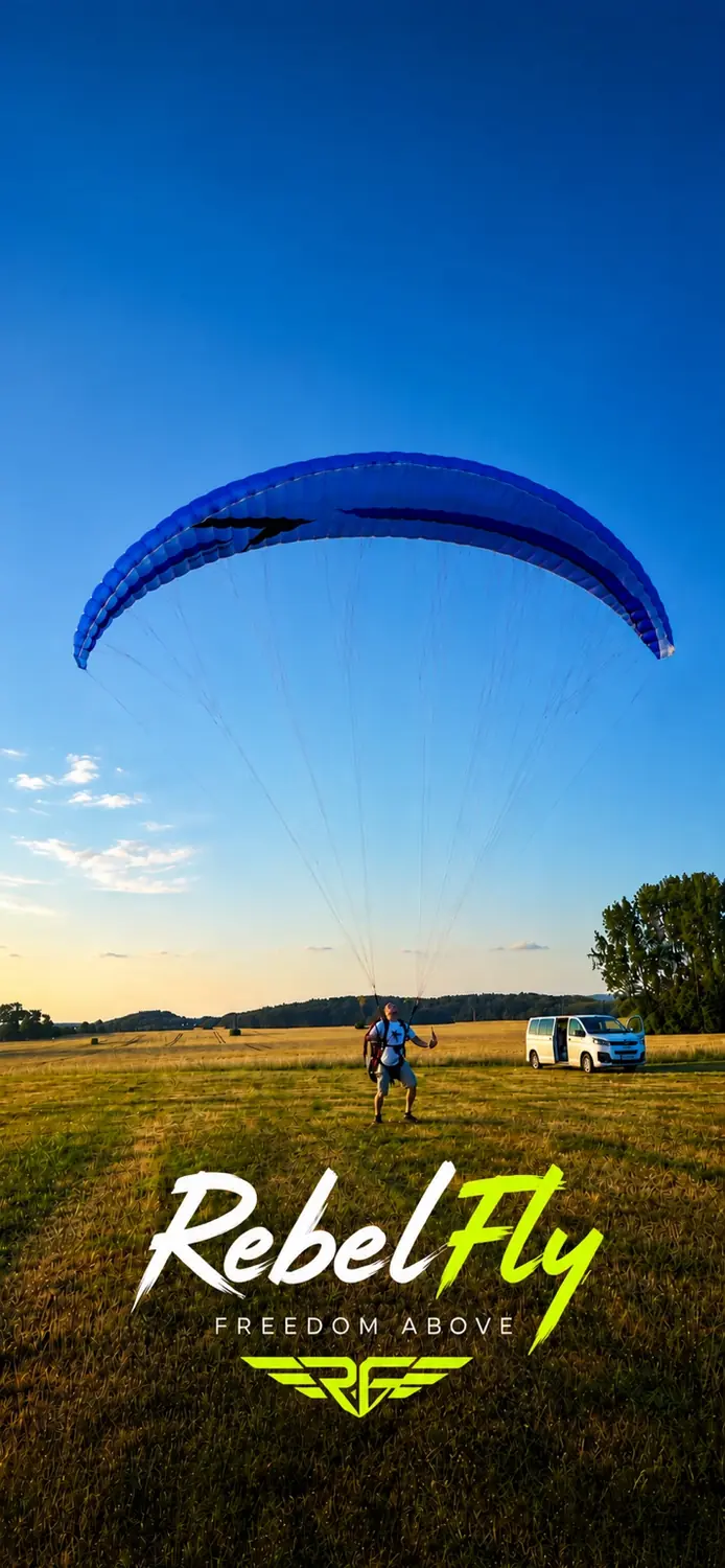 Frank unter seinem blauen Gleitschirm mit RebelFly-Schriftzug